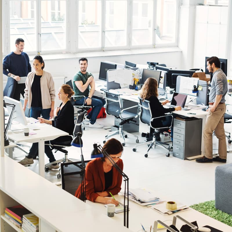 wide shot of employees working in an office with  a lot of digital devices