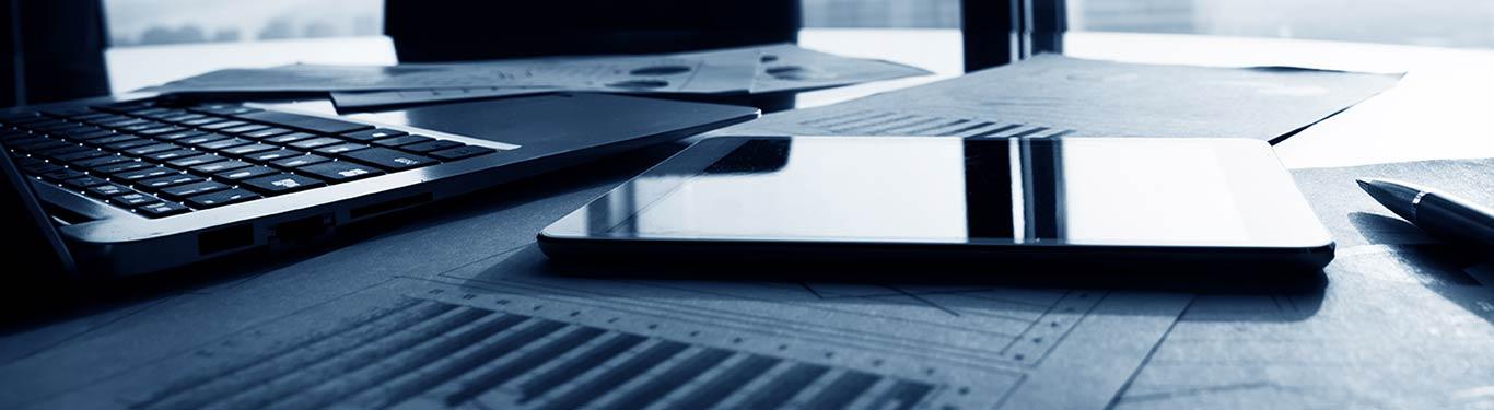 laptop & mobile phone on desk in low light