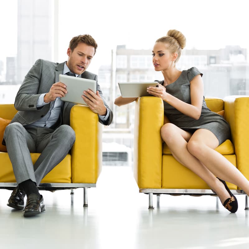 two business people conversing and comparing information on mobile devices