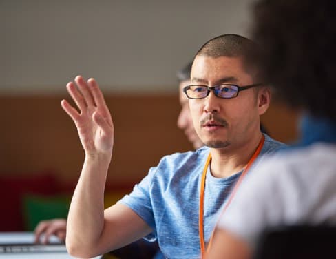 focus on man talking with arm up showing collaboration and discussion