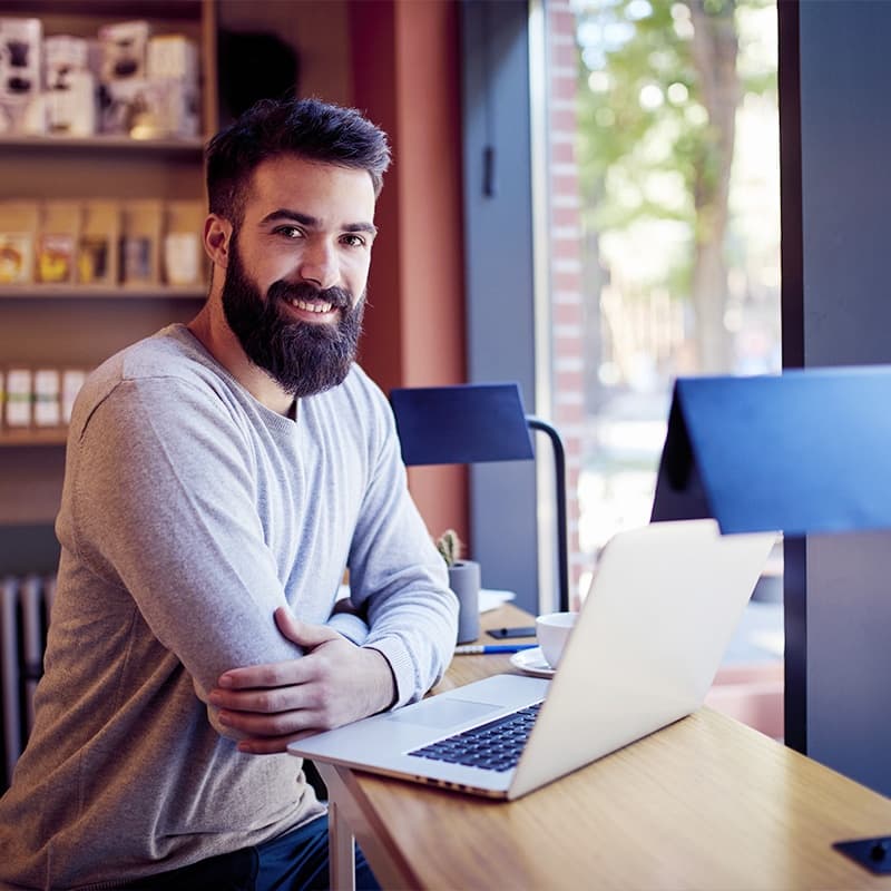 Casual businessman working on laptop while sitting in cafe