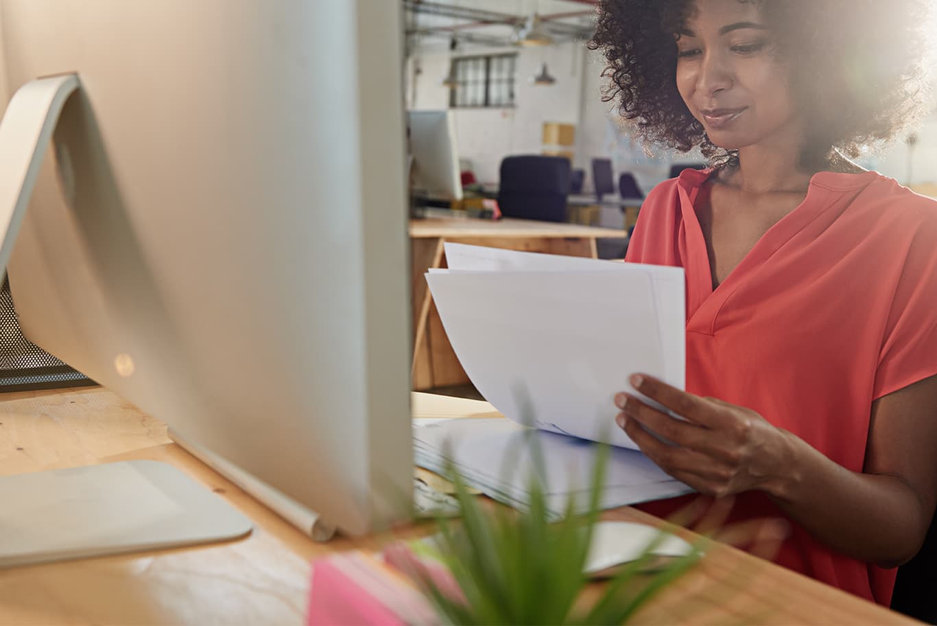 Woman looking at documents by computer