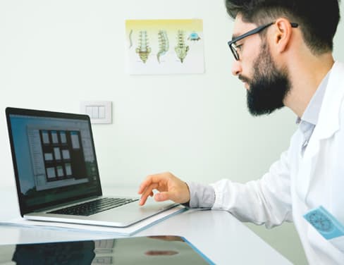 Doctor using laptop computer.