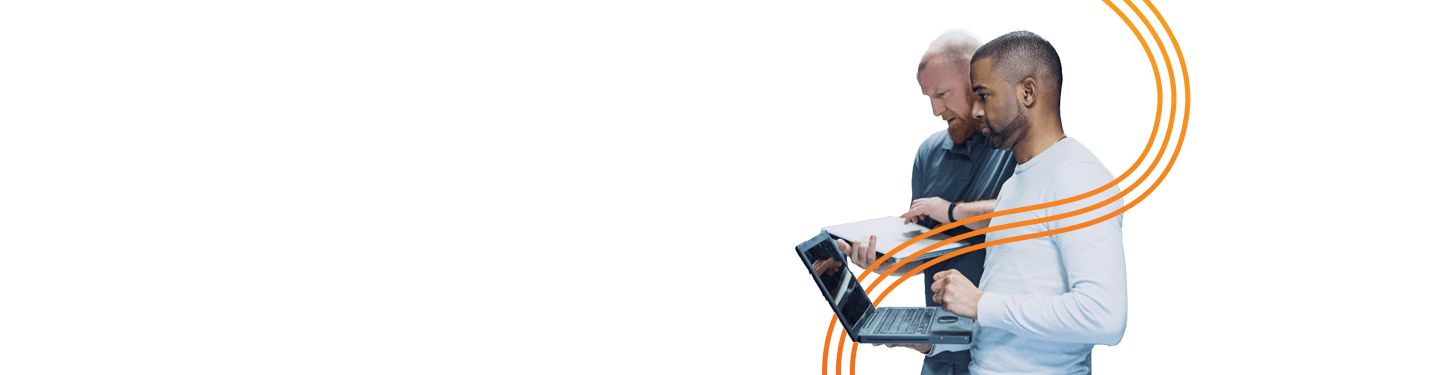 Two men standing working on laptops