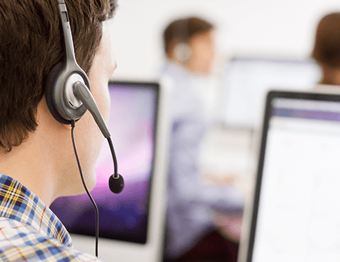 IT man with headset looking at screen