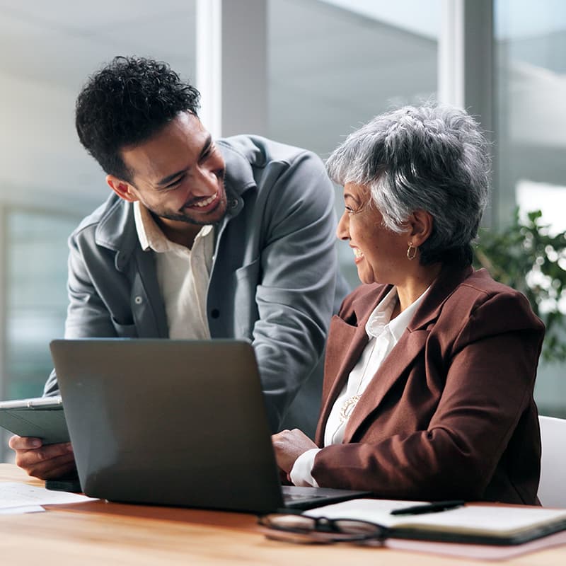 Young man and old woman discussing retirement plans and life insurance plans with the help of our 401(k) program, along with matching company contributions.