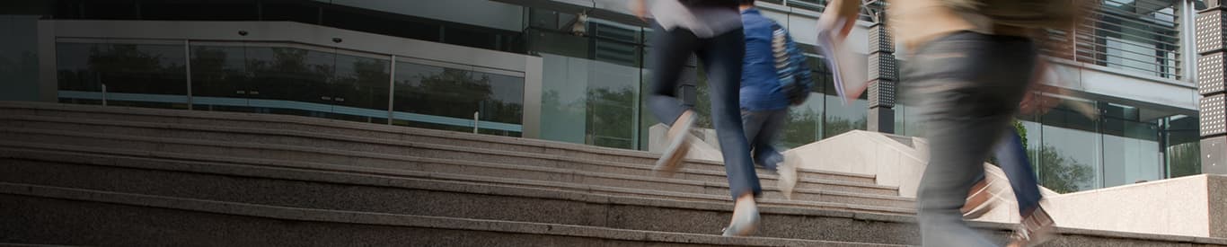 Students running to class up stairs on campus
