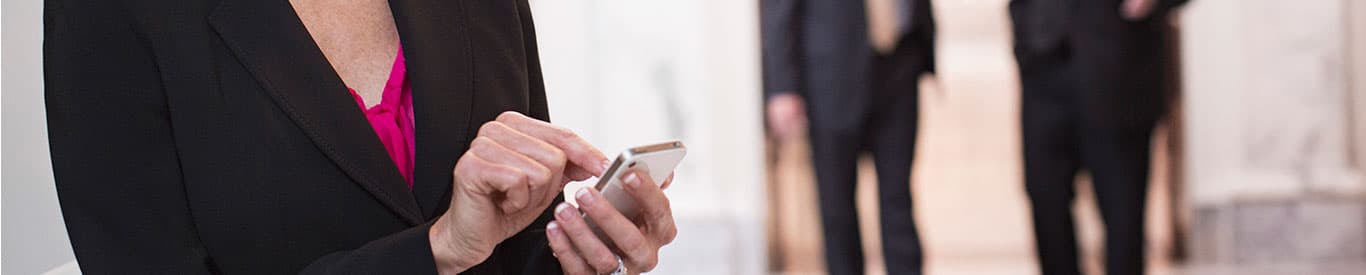 woman reviewing files on her mobile device within a government facility