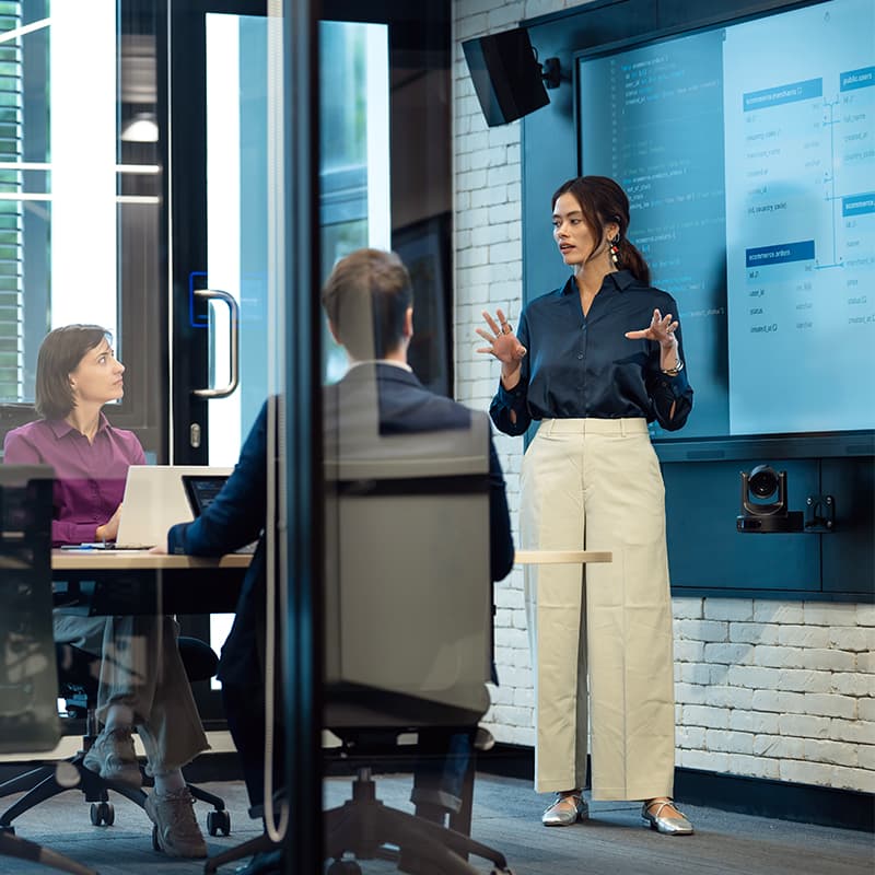 Woman presenting in an office setting, demonstrating numerous training and development opportunities, including the Ricoh Learning Institute, RPath to Development, and the Emerging Leader Program.