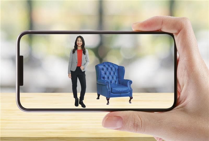 A mobile screen capturing an image of a woman standing next to a blue couch, as a part of bringing campaigns into the future with AR.