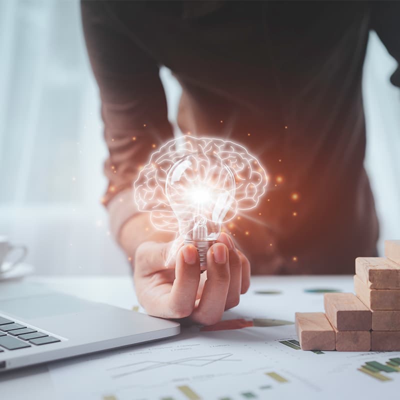 Man holding a lightbulb creating digital illusion, demonstrating innovation and outthinking the ordinary