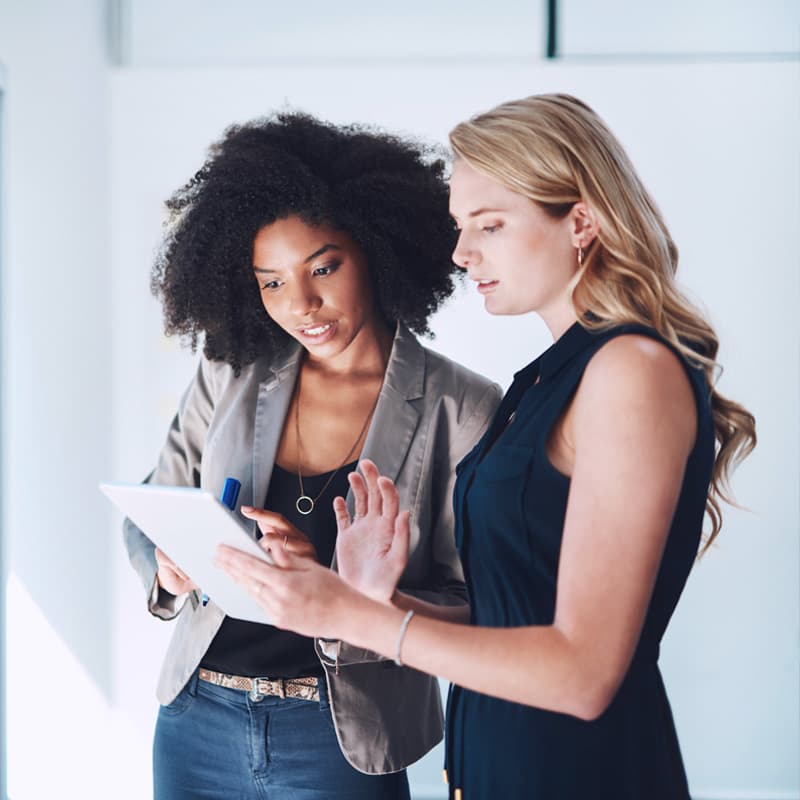 Shot of two businesswomen using a digital tablet together in an office